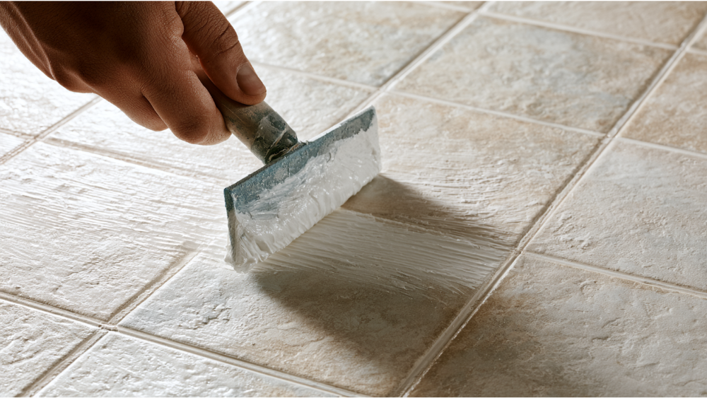 Using a rubber grout float to press grout into ceramic tile joints.