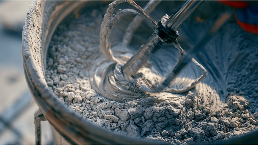 Mixing powdered grout to a smooth peanut butter consistency using a paddle mixer.