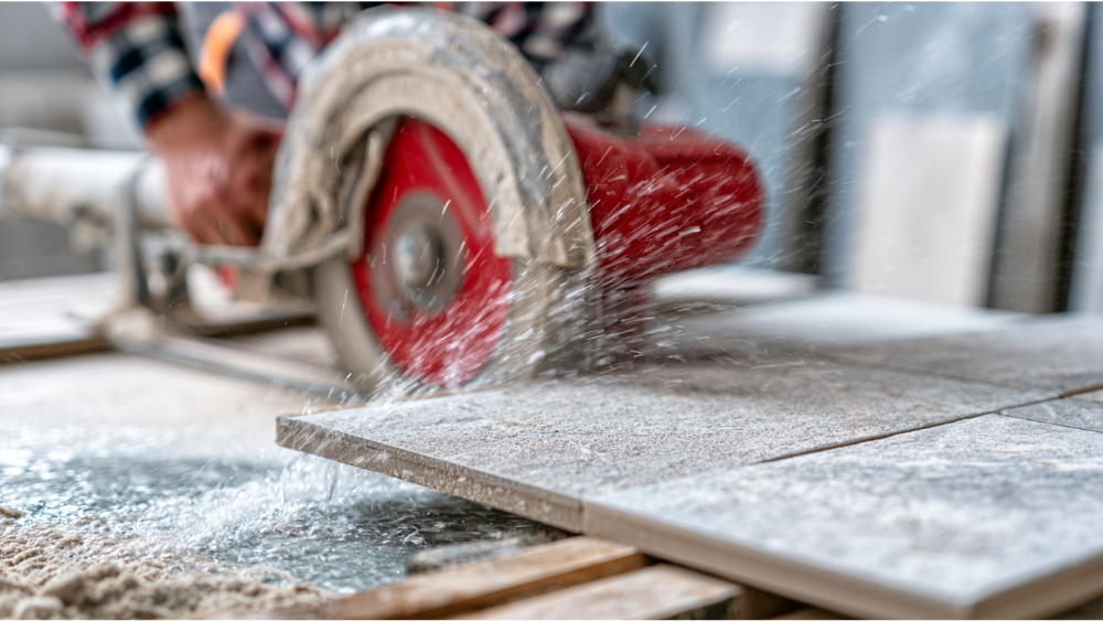 Professional using a wet tile saw to cut porcelain tile with a clean edge.